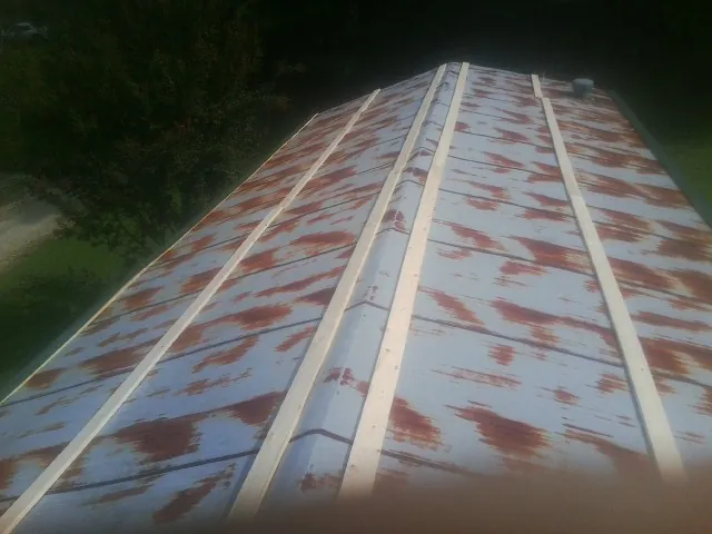Rusted metal roof panels with new wood purlins before replacement — Storm Damage Roof Repair in Tobias by Roofing Brothers