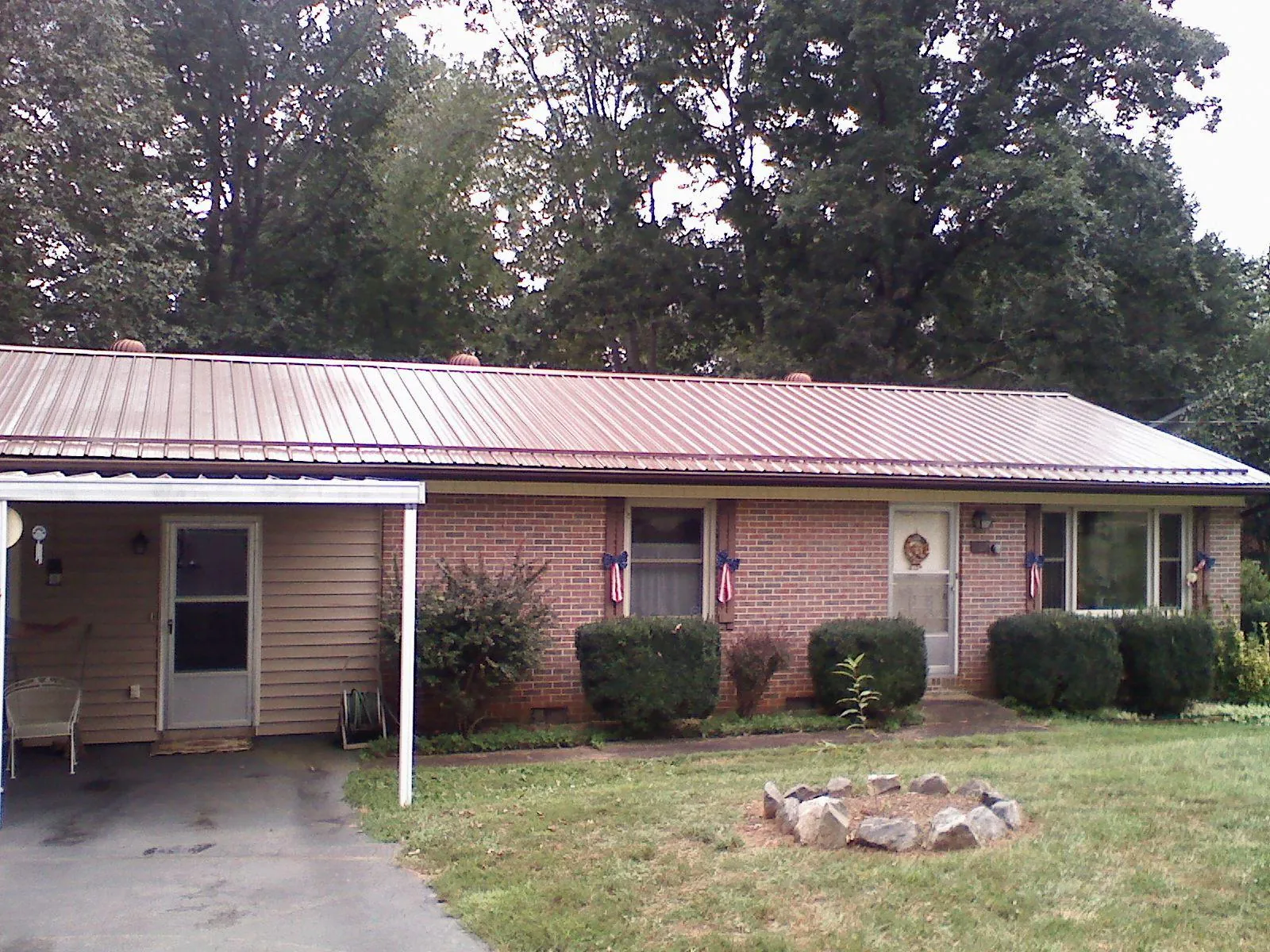Bronze metal roof and carport on a brick ranch home — Roof Repair work by our crew in Tobias