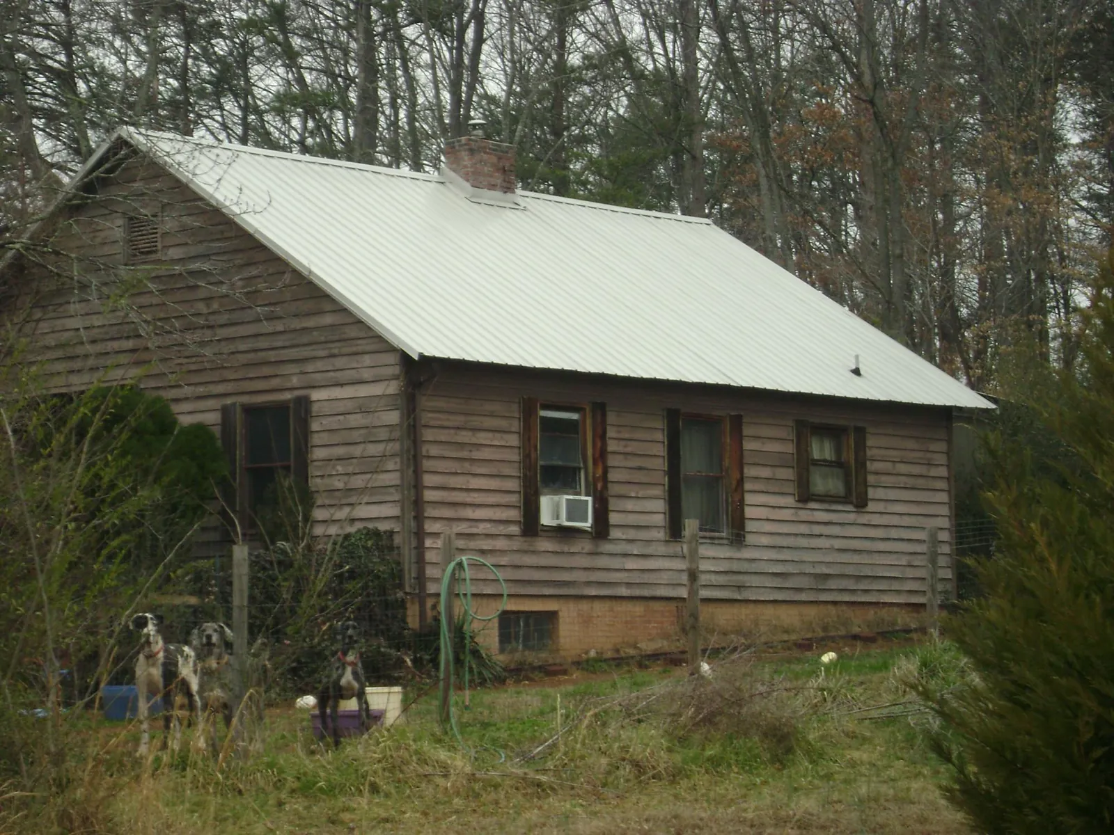 White metal roof on an old wood sided farmhouse, from a Metal Roof Installation job in Tobias